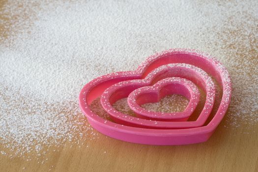 Pink cookie cutters on a wooden table