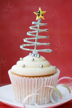 Cupcake decorated with silver dragees and a spiral Christmas tree