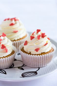 Cupcakes decorated with fresh cream and sugar hearts