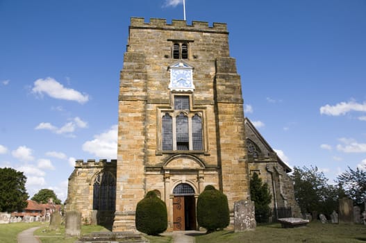 A rural church with clock tower and blue sky