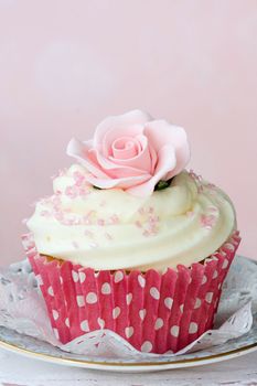 Cupcake decorated with a pink sugar rose