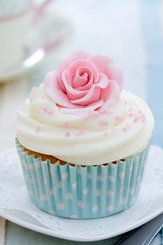 Cupcake decorated with a pink sugar rose