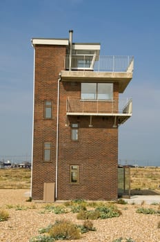 A coastguard lookout tower on the beach at Dungerness , England
