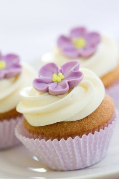Mini cupcakes decorated with a purple sugar flower