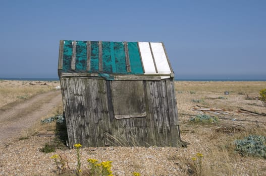 An old abandond fishing hut on a shingle beach