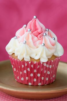 Pink and white cupcake decorated with silver dragees