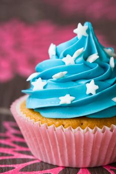 Blue and pink cupcake decorated with white sugar stars