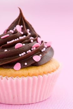 Pink chocolate cupcake against a pink background