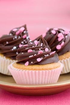 Trio of pink chocolate cupcakes on a plate