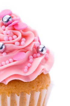 Closeup of a pink cupcake isolated against white