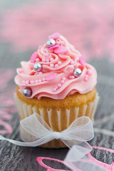 Pretty pink cupcake tied with an organza ribbon