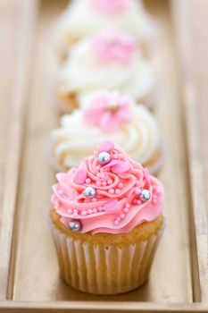 Pink and white cupcakes arranged on a tray