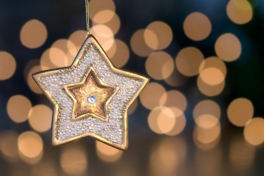 Christmas star hangs in front of de-focused christmas lights