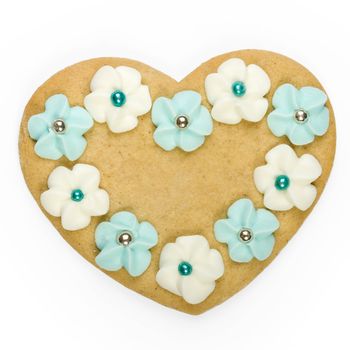 Heart shaped gingerbread cookie decorated with sugar flowers