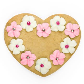 Heart shaped gingerbread cookie decorated with sugar flowers