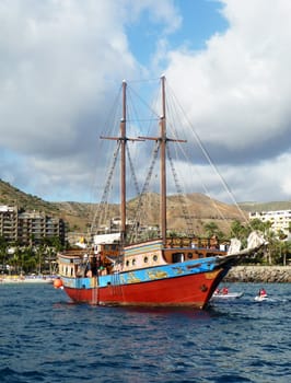 An old fashioned sail boat in a harbor.