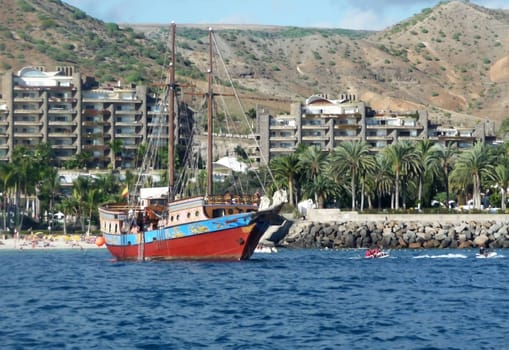 An old fashioned sail boat in a harbor.