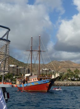 An old fashioned sail boat in a harbor.