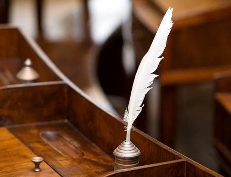 ancient inkwell and feather on the old table