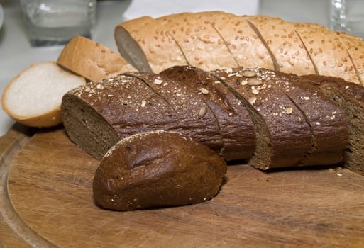 Pieces of different sort of bread on wooden cutting board