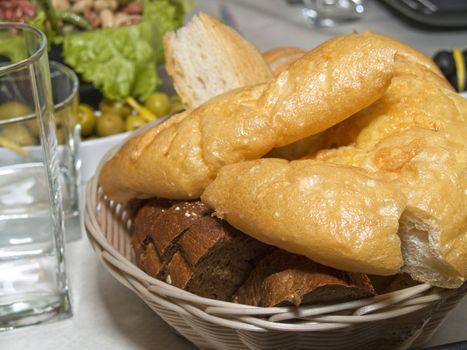 Pieces of different sort of bread and Italian chiabatta in biscuit dish on the served table