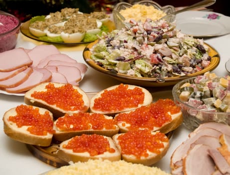 Table covered for a celebratory dinner. Sandwiches with red caviar.