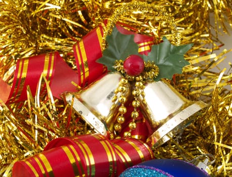Christmas ornaments - bells and ribbon on gold tinsel background