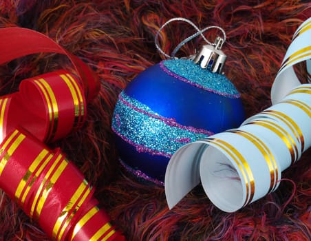 Christmas blue ball and color ribbons on a fluffy background