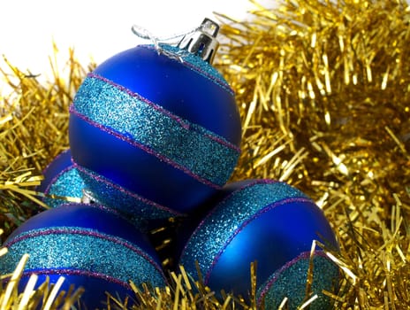 Christmas blue ornaments and gold tinsel on white background