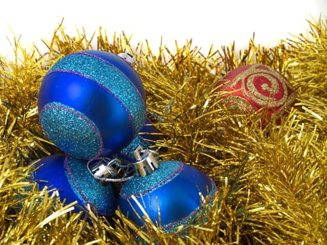 Christmas blue ornaments and gold tinsel on white background