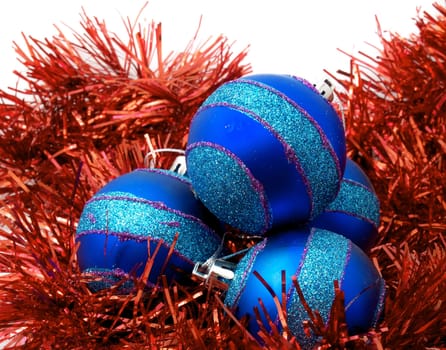 Christmas blue ornaments and red tinsel on white background