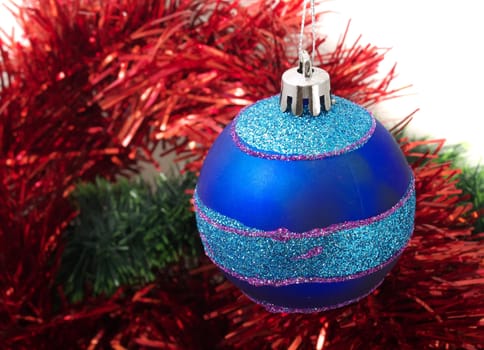 Christmas blue ornaments and red tinsel on white background