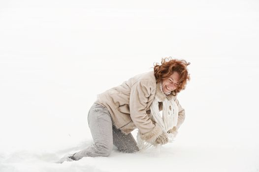 Attractive red-haired woman having fun in winters day.