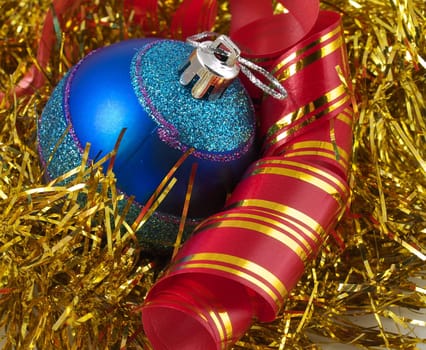 Christmas blue ornaments and colorfull  ribbon on background of gold tinselbackground