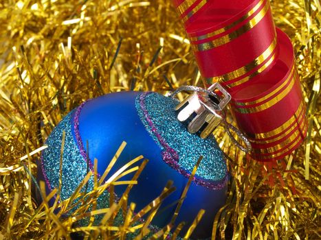 Christmas blue ornaments and colorfull  ribbon on background of gold tinselbackground