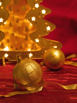 Christmas gold ornaments and gold with lamp like fir on the red background