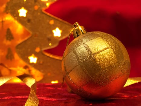 Christmas gold ornaments and gold with lamp like fir on the red background