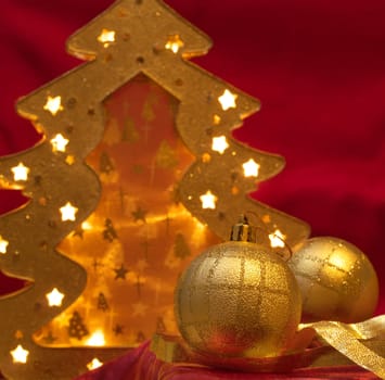 Christmas gold ornaments and gold with lamp like fir on the red background