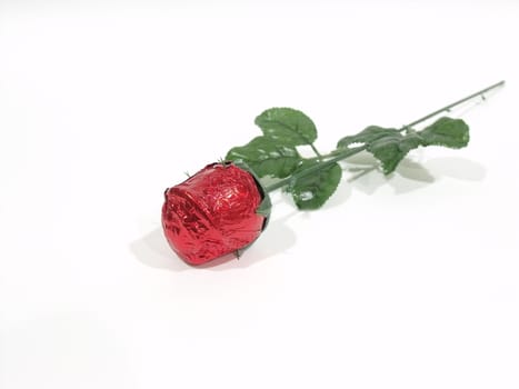 Isolated artificial red rose on a white surface