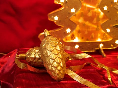 Christmas gold ornaments and gold with lamp like fir on the red background