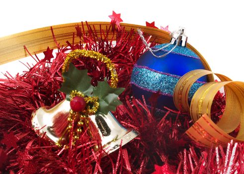 Christmas ornaments - bells, blue ball and red tinsel on white background