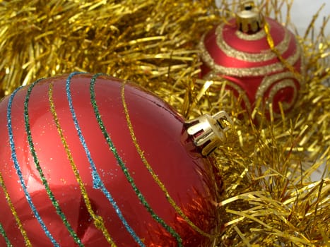 Christmas red ornaments and gold tinsel on white background