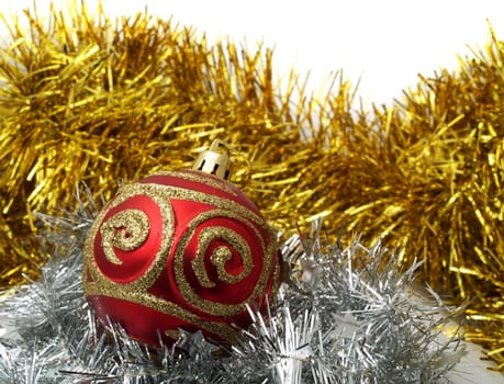 Christmas red ornaments and gold tinsel on white background