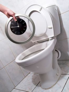 Hand throwing clock per a toilet bowl. Flush time into a toilet, dally away