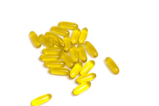 close up on stack of yellow vitamin capsules, isolated on white