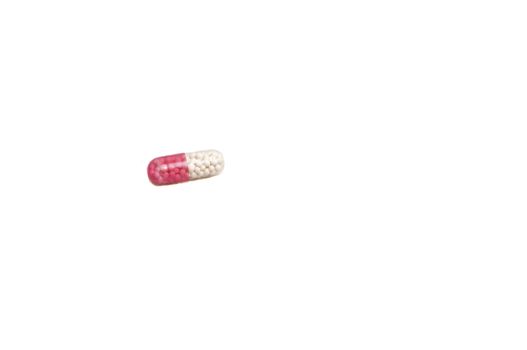close up on a pink and white capsule, isolated on white with space for copy