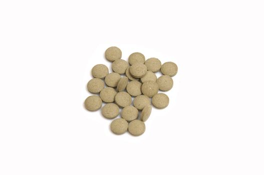 close up on a stack of brown, pills, isolated on white with space for copy
