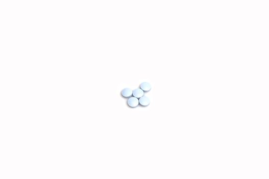 close up on a small stack of blue pills, isolated on white with space for text