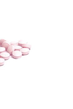 stack of pink pills, isolated on white with space for copy