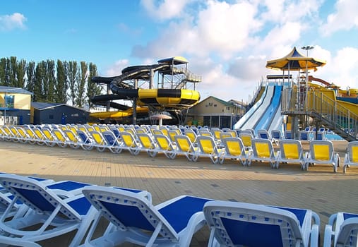 Empty aquapark before opening. It is a lot of armchairs and waterslides   